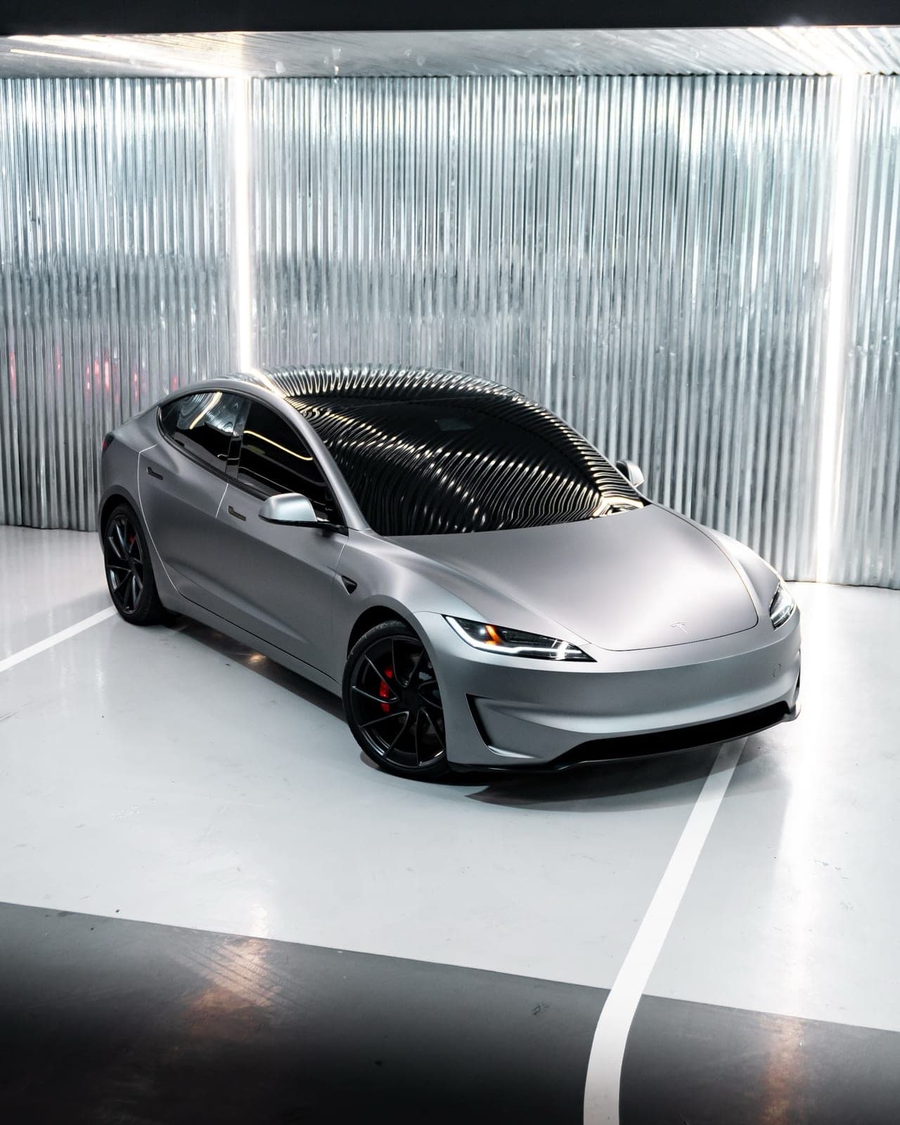 Tesla Model 3 — silver front three-quarter exterior